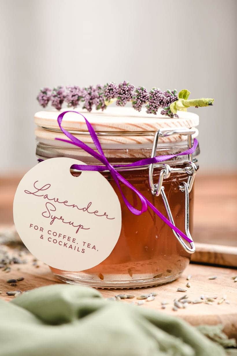 Lavender syrup in a jar tied with a bow and a sprig of lavender on top