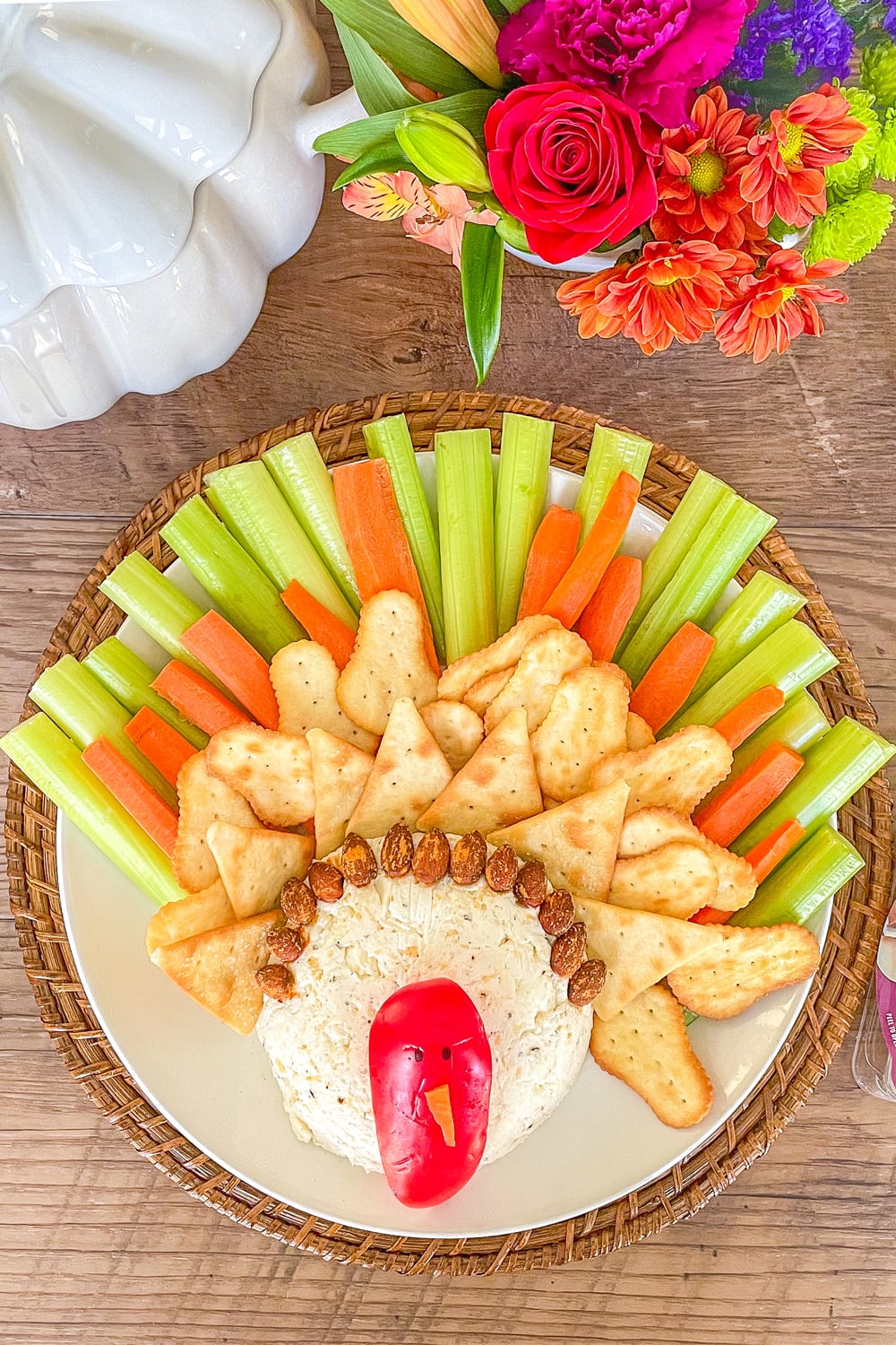 Cheese ball made to resemble a turkey with a red pepper face, and carrots, celery and crackers for the feathers.